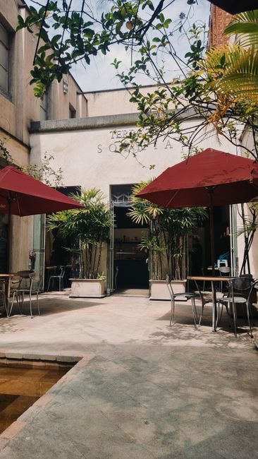 Cafetería al aire libre en Medellín con mesas, sillas y sombrillas