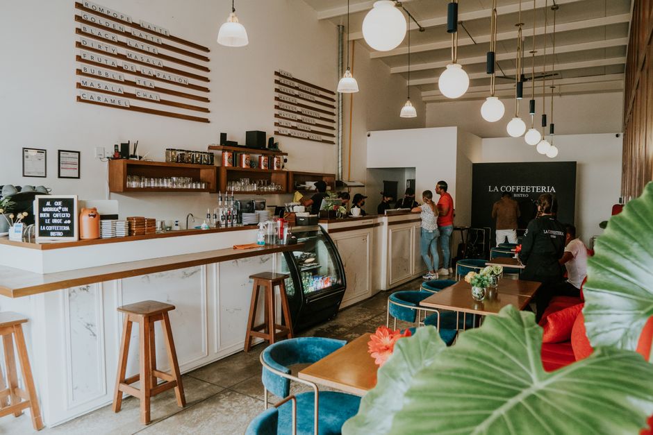 Cafetería moderna con clientes disfrutando bebidas y decoración elegante