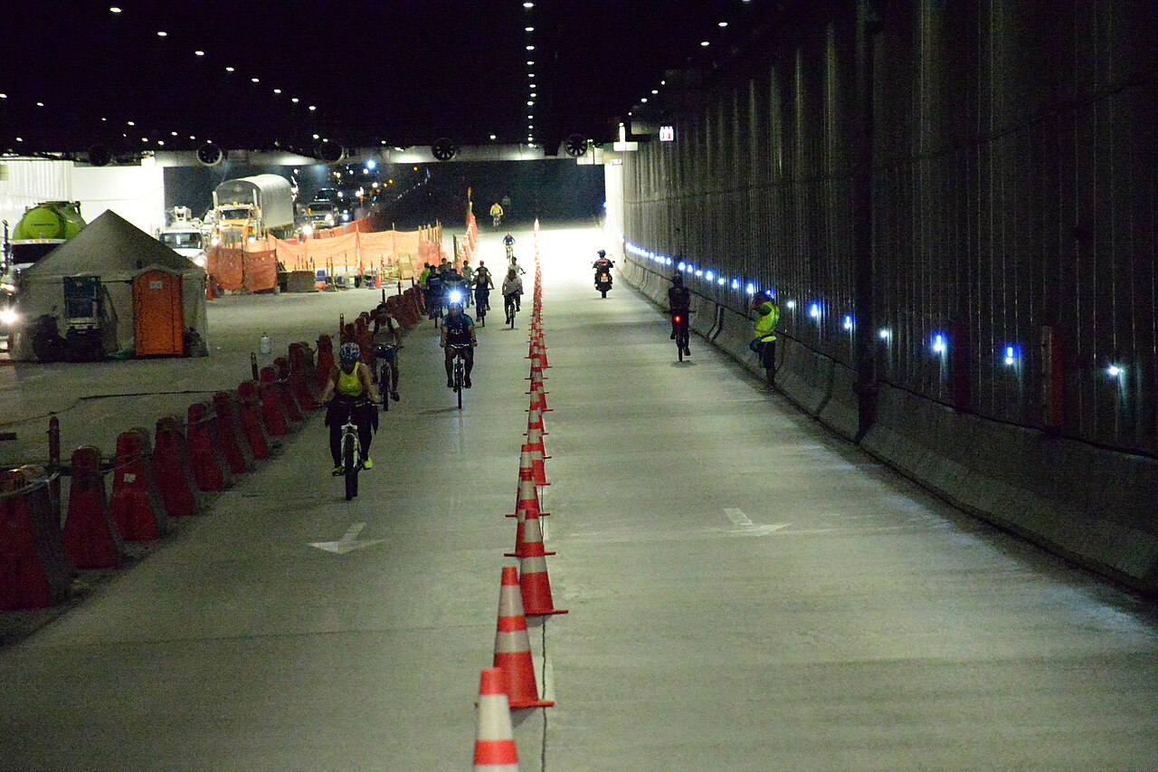 Cyclists riding through the road underpass converted into a cycle path at Parques del Río Medellín in 2019