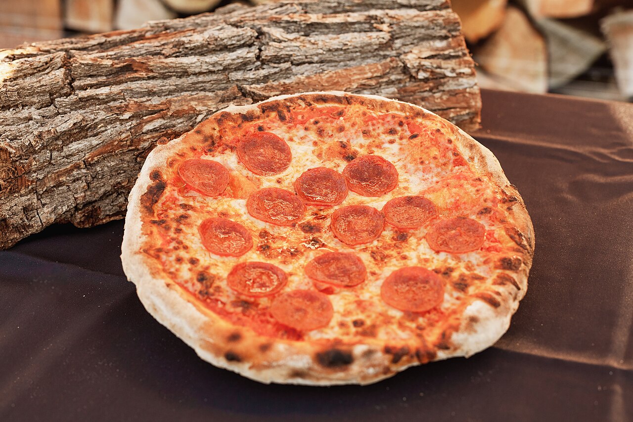 Pepperoni pizza in front of a wood-fired oven