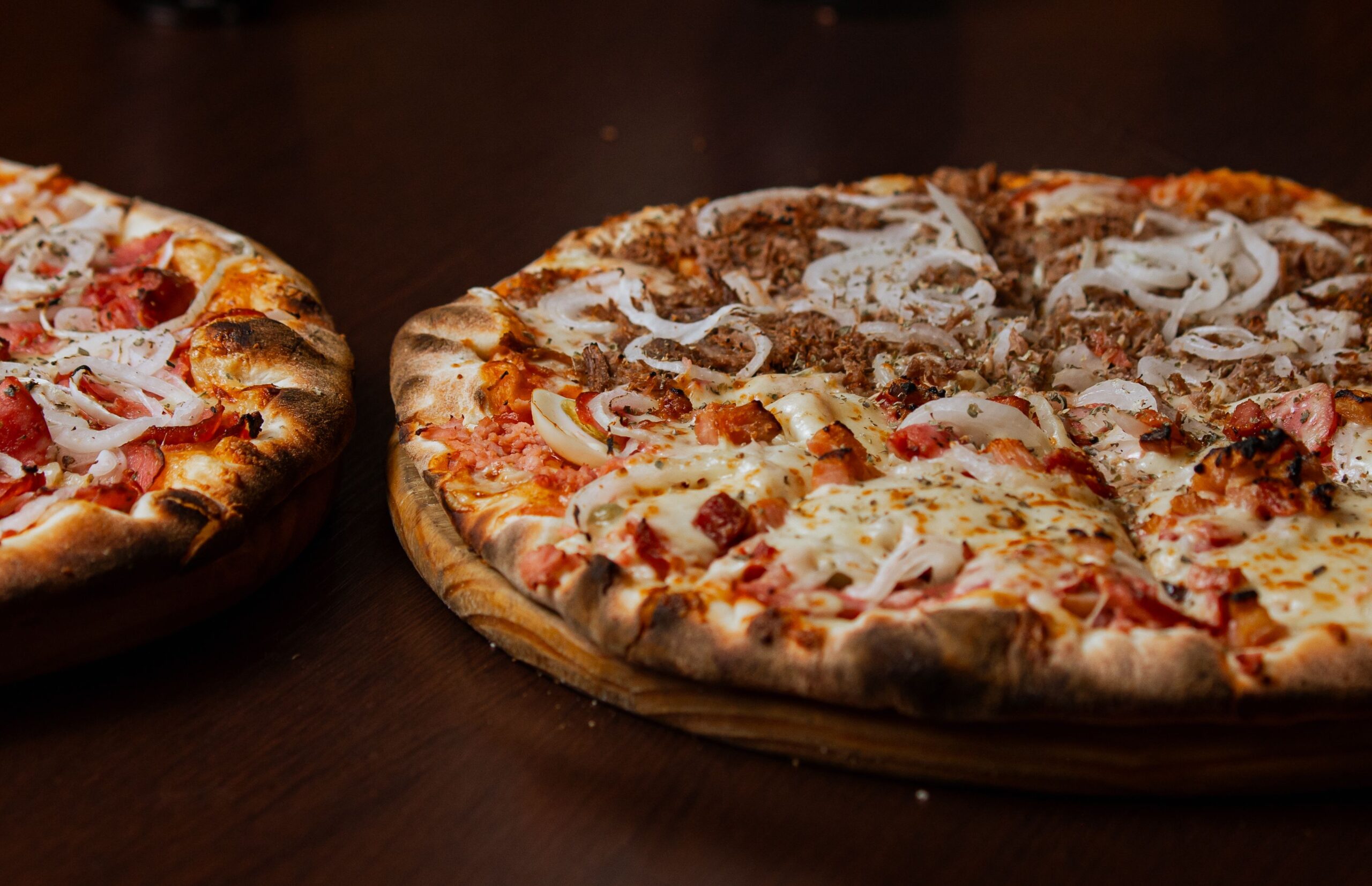 Dos pizzas deliciosas con pepperoni y cebolla