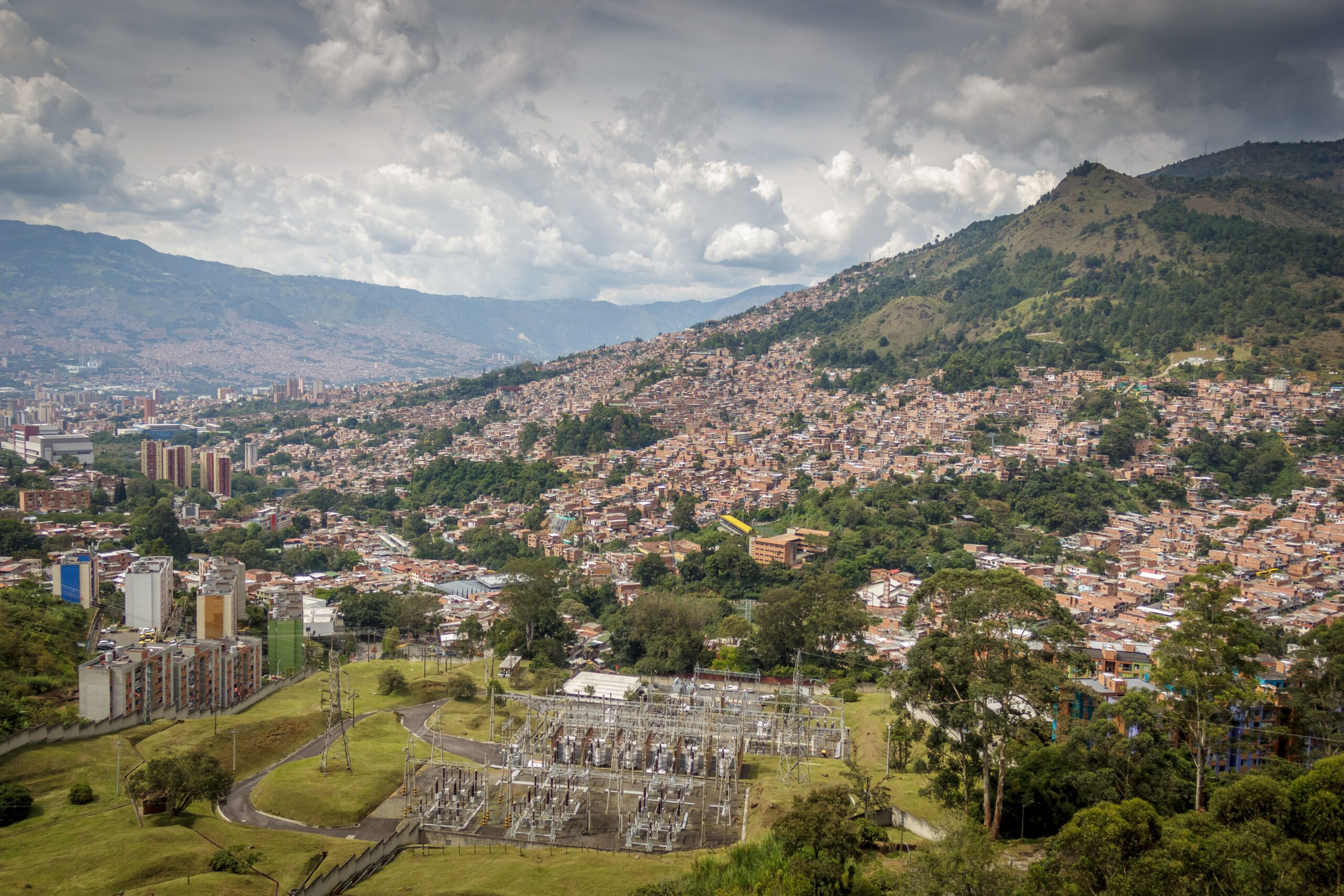 Explora el paisaje urbano de Medellín con fondo montañoso