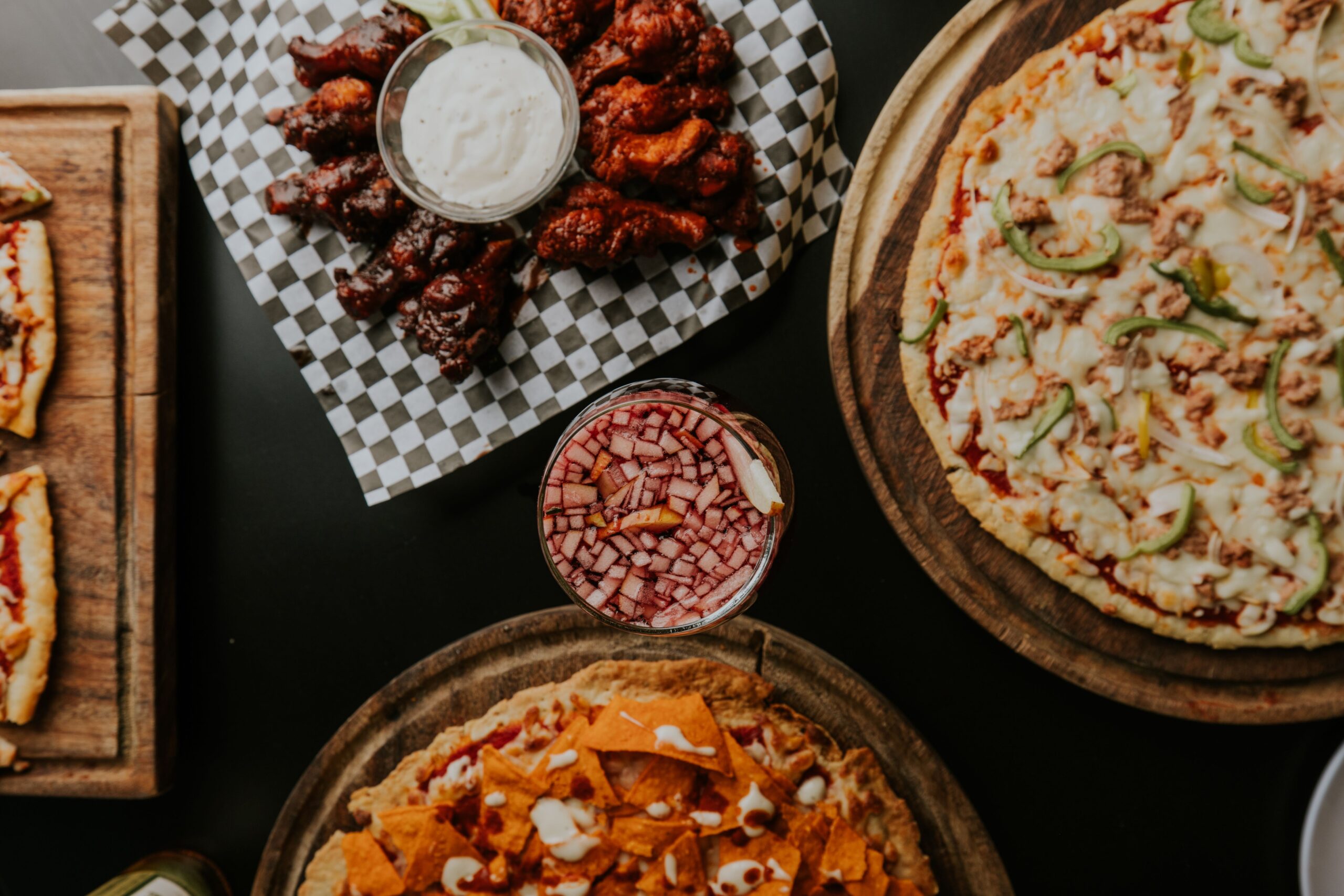 Variedad de pizzas y alitas de pollo en una mesa de restaurante
